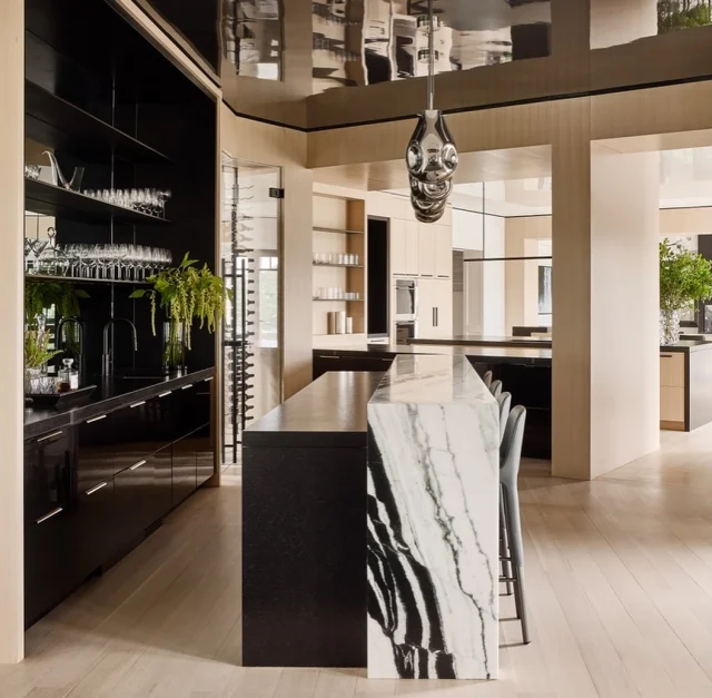 Sometimes the best plan is no plan at all.
A night in can be just as memorable and glamorous.
We love the return of the home bar—eye-catching, functional, and designed to elevate any interior.

This custom bar pairs a dramatic marble countertop with oak paneling and a curated wine display—a space where every pour feels like a celebration.

In collaboration with @amyhirsch_design
Photography @readmckendree