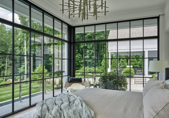 A guest room that feels like a breath of fresh air.
Framed in charcoal aluminum, the floor-to-ceiling glass invites the landscape in—opening the space to views of the lush patio and rolling grounds, and creating an atmosphere of calm and connection. 
As the homeowner said, “When I was indoors, I really wanted to feel the outdoors.” The result: a tranquil retreat where guests say they’ve never slept better.

📍Featured in @nehomemagazine
Developer and Builder: @sbphomes 
Architecture: @apdarchitects 
Interior Design: @sbphomes @nimadesigninteriors 
Landscape Design: @sbphomes @williamkennyassociates 
Photography: @readmckendree
Floral: @greenofgreenwich