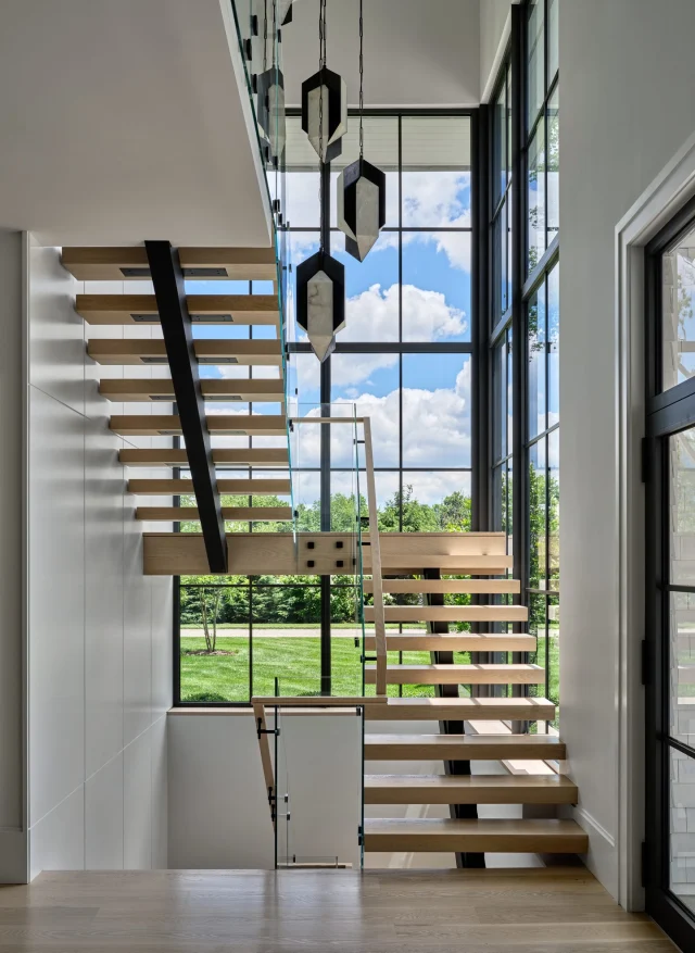 A true statement of arrival.
The front entry sets the tone with a soaring glass stair tower—anchored by floating oak treads and illuminated by a sculptural cluster of @kellywearstler pendants. Dramatic yet refined, it captures the balance of architecture and artistry at the heart of this home.

Seen in @nehomemagazine
Developer and Builder: @sbphomes
Architecture: @apdarchitects
Interior Design: @sbphomes @nimadesign
Photography: @readmckendree